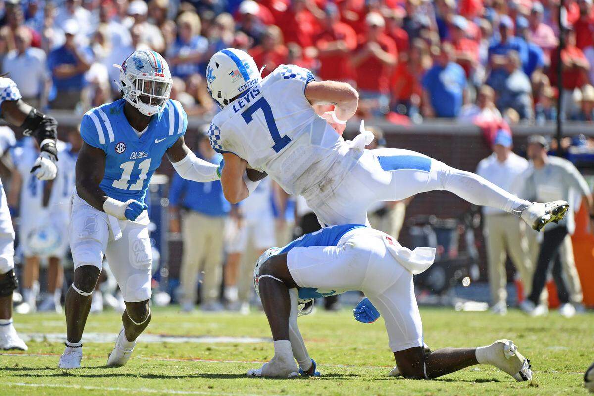 Ole Miss safety AJ Finley (21) and linebacker Austin Keys (11) force a fumble by Kentucky quarterback Will Levis (7) in Oxford, Miss., on Oct. 1. The Cats lost 22-19.