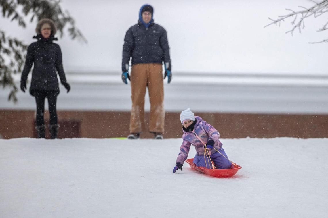 Mia Buhr, 5, sledded down a hill as her parents, Neeley Buhr, from left, and Jeff Buhr, watched in Lexington Tuesday.