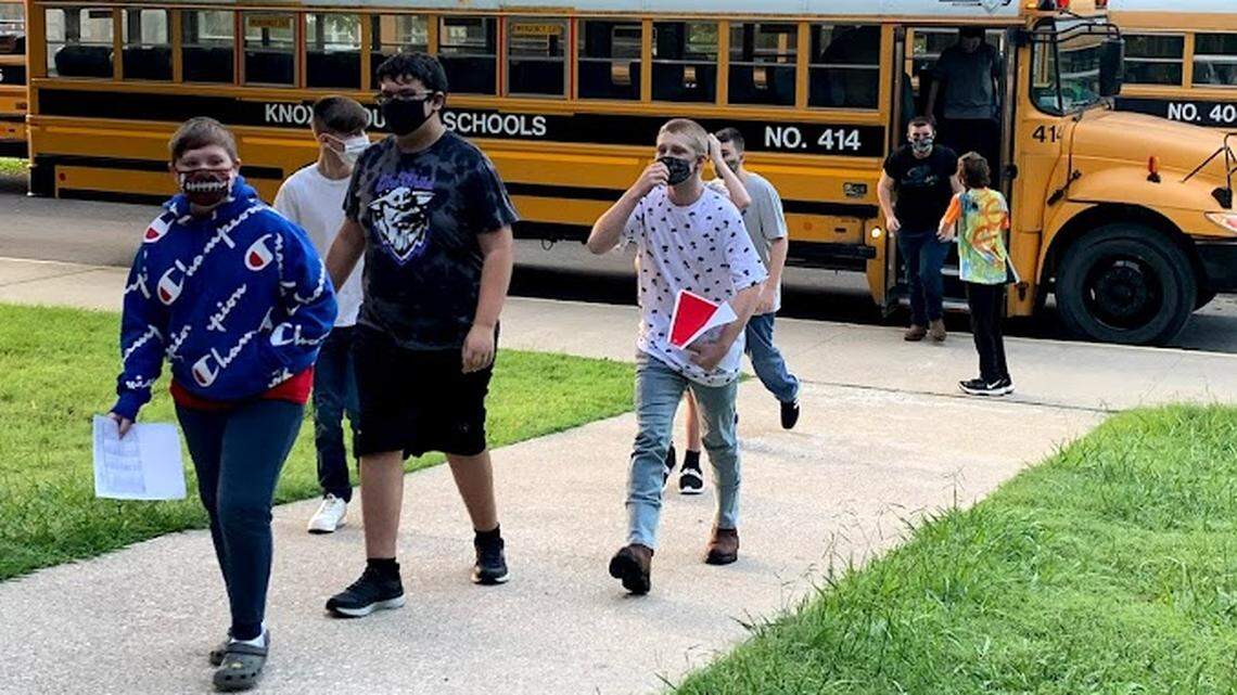Knox County Middle School students enter their campus holding materials needed for the school day. Knox County Schools have banned backpacks.