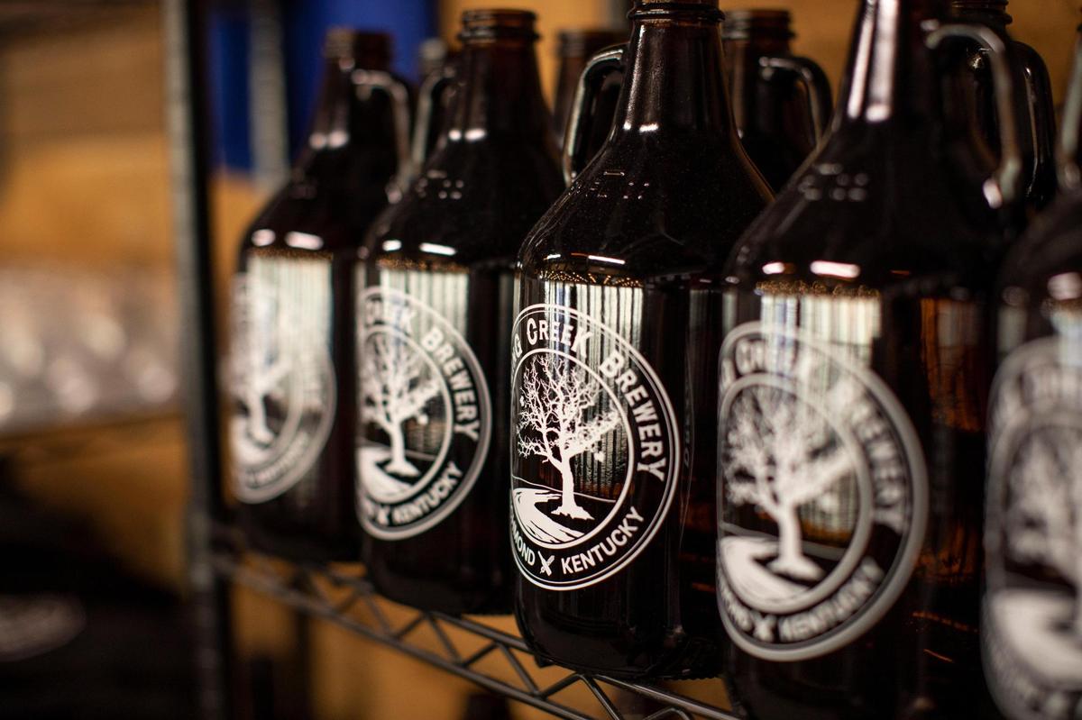 Bottles with the logo for Dreaming Creek Brewery are on display Nov. 16 behind the Richmond bar. Dreaming Creek Brewery now offers many of their beers in cans after the COVID pandemic made takeout orders more popular than traditional dining in.