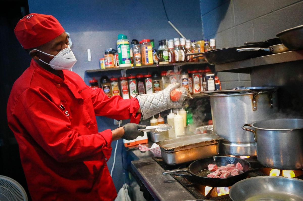Robert Williams, of Lexington, Ky., executive chef at Mr. Krabs & Bean’s BBQ prepares lobster tail and steak bites in the restaurant’s kitchen in Lexington, Ky., Thursday, Nov. 19. 2020.