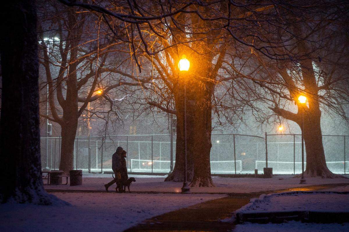 Pedestrians walk through Woodland park as snow falls in downtown Lexington, Ky., Wednesday, January 27, 2021. The National Weather Service has predicted a low of 20 degrees Wednesday night and a high of 32 Thursday.