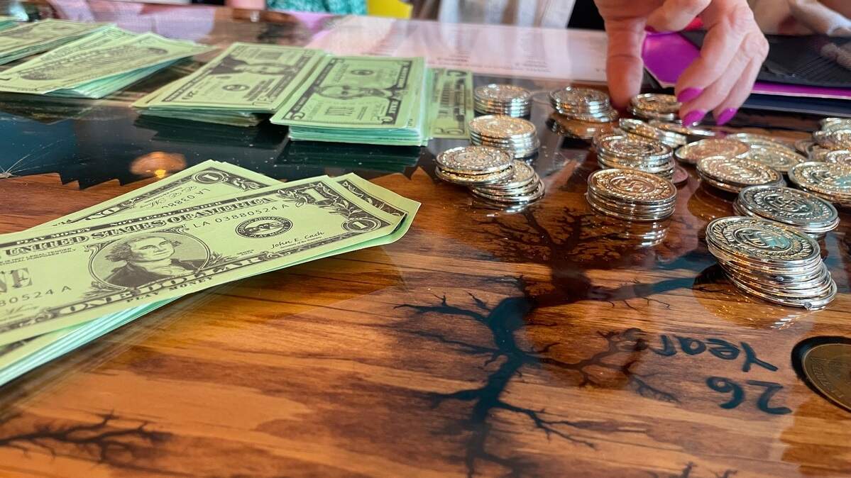 Tables were set up at a re-entry simulation event where bus tokens were purchased for transportation. The event was intended to show people how difficult it is to re-enter society after being jailed.