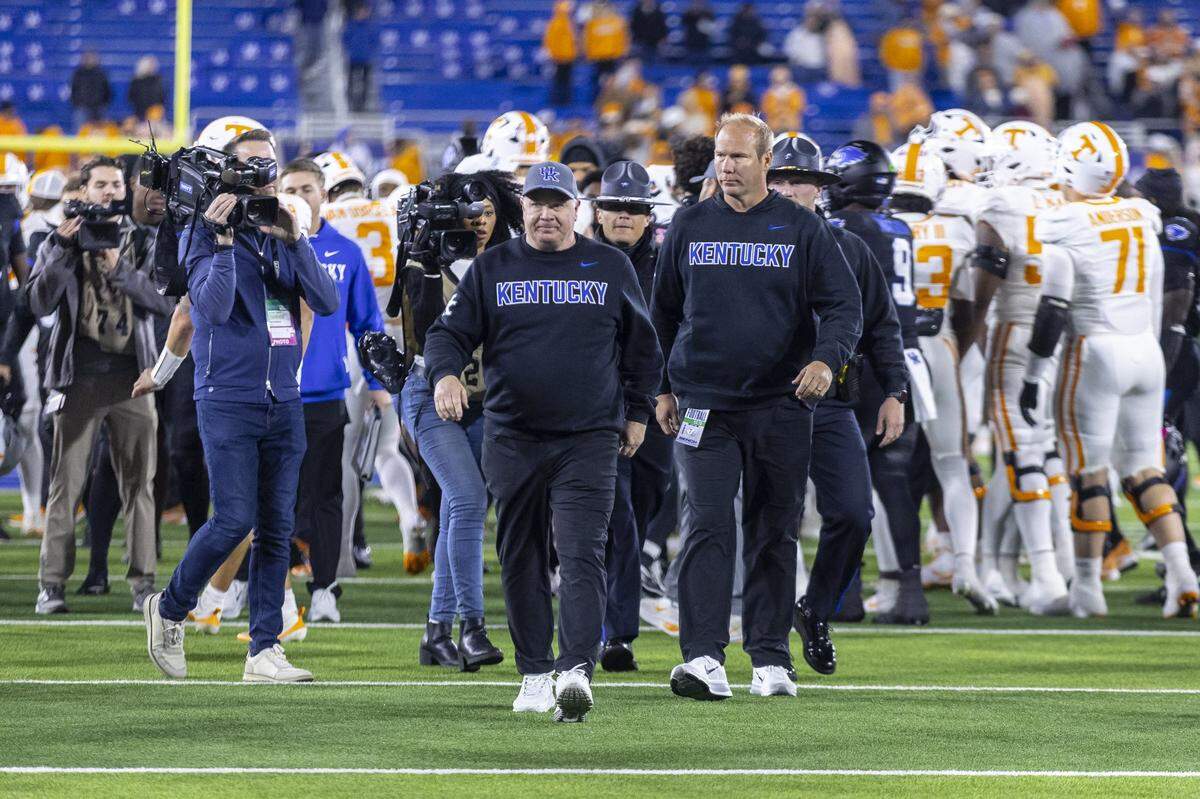 Kentucky head coach Mark Stoops, in foreground, walks off the field following Saturday’s 56-34 loss to Tennessee at Kroger Field.