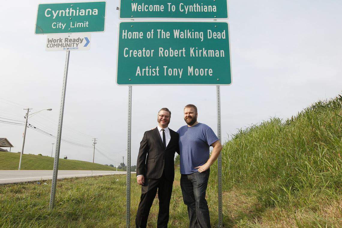 Comic book writer Robert Kirkman and artist Tony Moore stand in front the city welcome sign that includes their names on Saturday, August 5, 2016, before the opening of The Walking Dead Day in downtown Cynthiana, Ky.