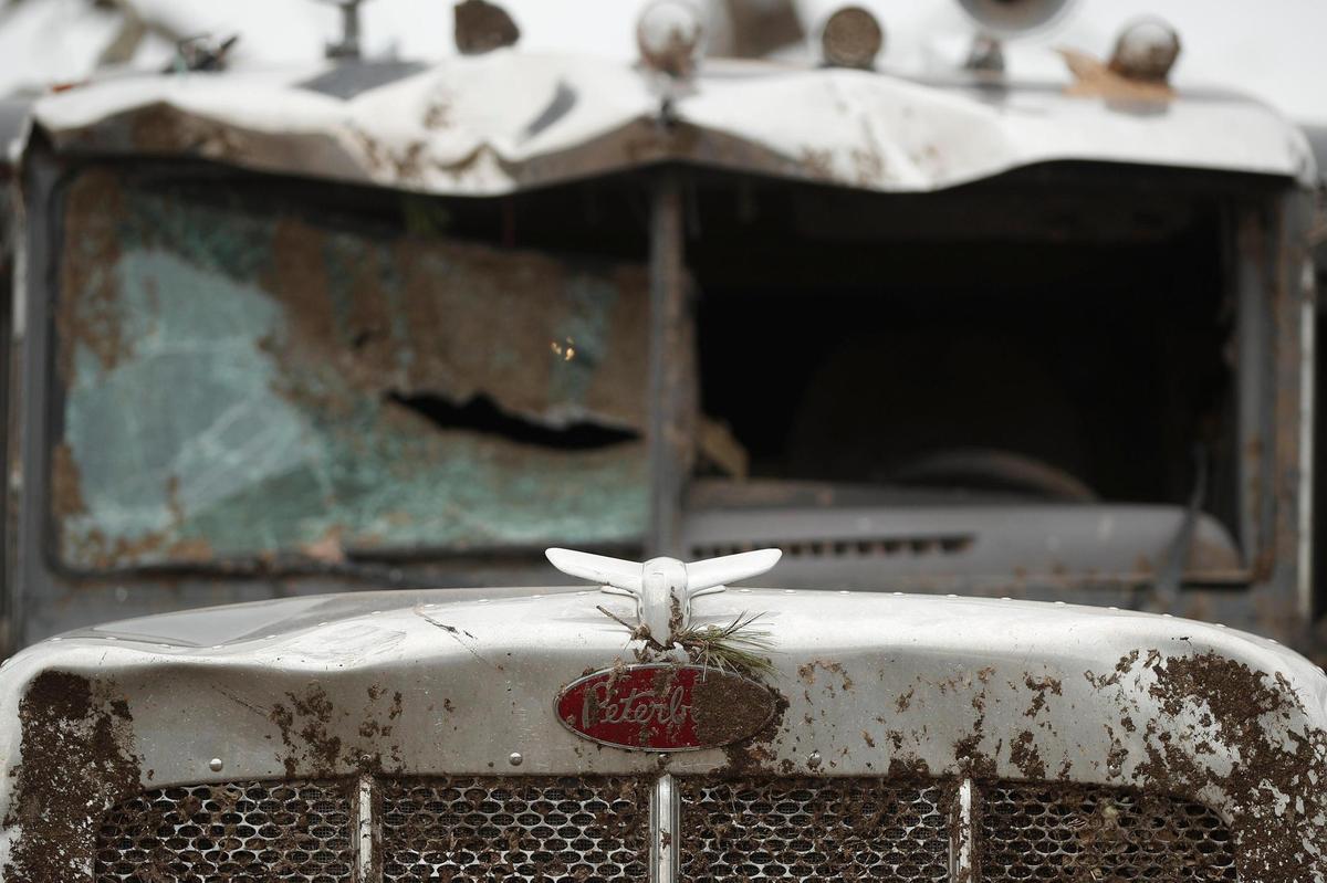 The hood ornament of a Peterbilt semi-truck sits intact around the ruins of the rest of the vehicle along East North Street in Mayfield, Ky.
