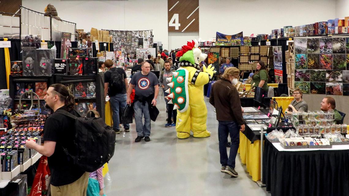 Patrons, including someone dressed up in cosplay as Bowser from Super Mario Bros., wander the exhibit floor during the 2022 Lexington Comic and Toy Convention at the Central Bank Center in Lexington, Ky. on Sunday, March 27, 2022.