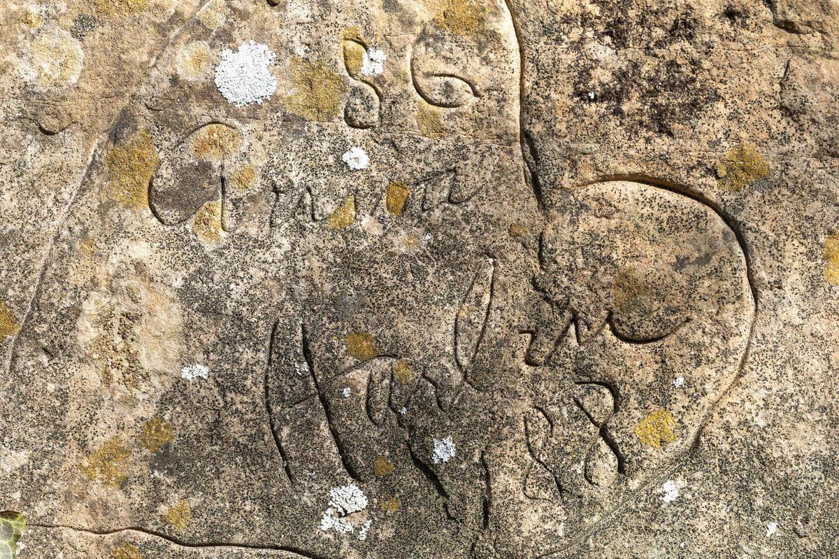 Anna and Harlan Hubbard’s signatures, carved into a rock, marks the spot where they are buried at Payne Hollow in Trimble County, Ky., on Thursday, March 6, 2025. The Hubbards lived off their land in a very remote and sustainable way for about 40 years at Payne Hollow.
