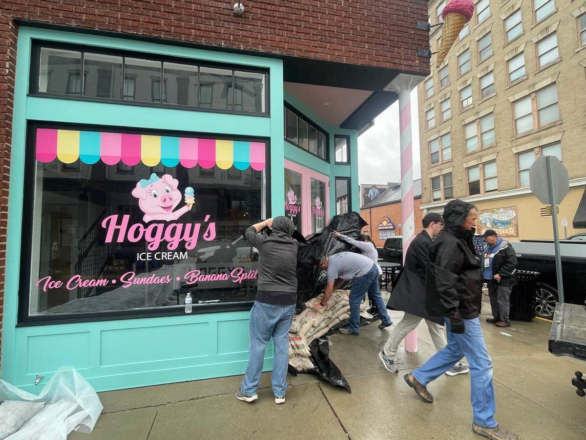 People help board up popular Hoggy’s Ice Cream shop in downtown Frankfort ahead of flooding on Sunday afternoon.