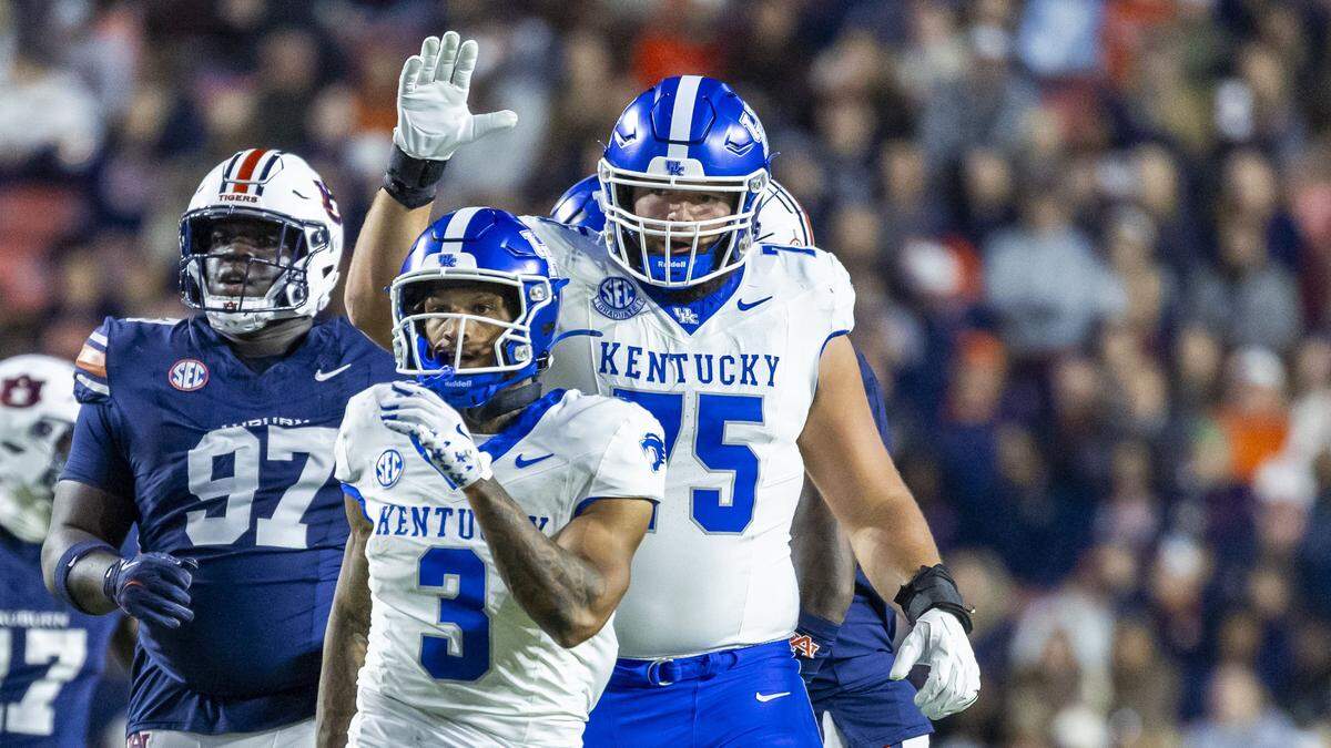 Kentucky offensive lineman Joshua Braun (75) gives running back Seth McGowan (3) a tap on the head after a run during a UK’s 10-3 win against Auburn on Nov. 1.