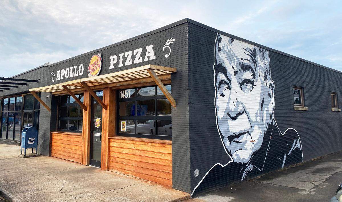The Apollo Pizza Lexington location on Leestown Road in the Meadowthorpe neighborhood features a mural of John Prine on the building.