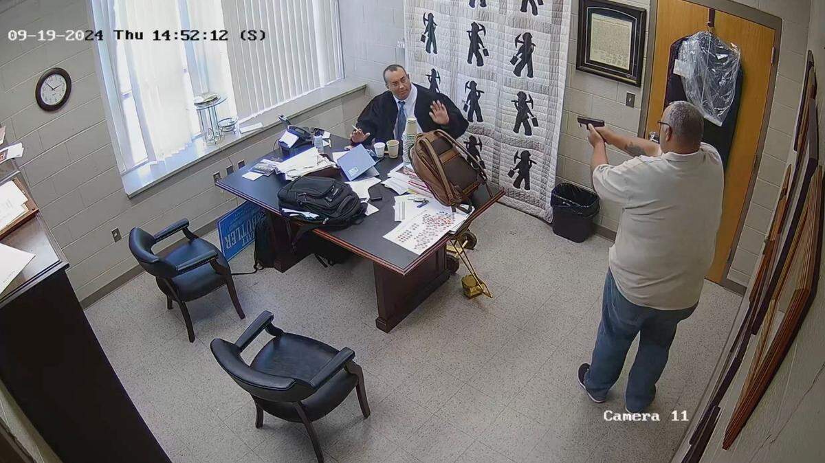 A frame grab from released video surveillance footage shows then-Letcher County Sheriff Shawn “Mickey” Stines, right, standing in the office of District Judge Kevin Mullins Sept. 19, 2024 before he fatally shot the judge. Stines was charged with murder in the death of Mullins.