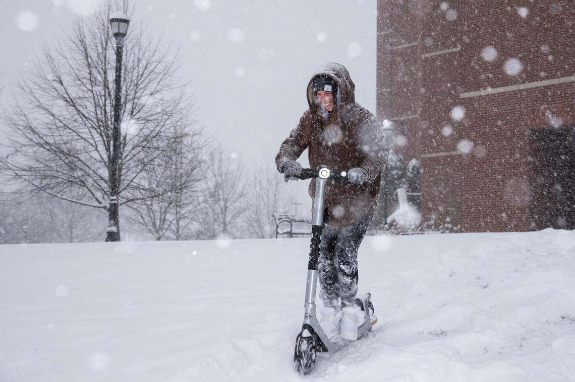 Sophia Lewis rides an electric scooter down a hill outside William T. Young library as snow falls for the first time in the new year in Lexington, Ky., Thursday, January 6, 2022.