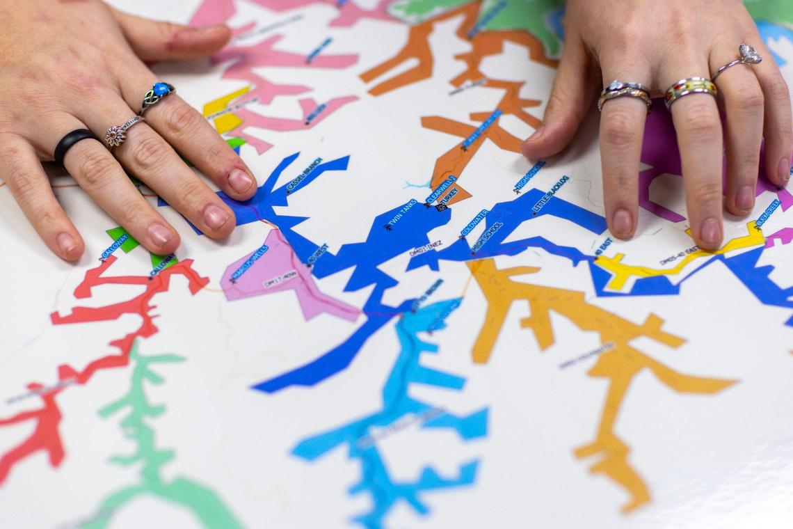 Madison Mooney, Liken Knowledge community engagement coordinator, holds a map of Martin County’s water system on Thursday, Feb. 22, 2024, in Inez, Ky.