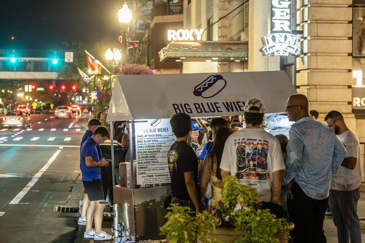 Chris Price, the owner and operator of Big Blue Wiener, serves customers at his stand near Henry A. Tandy Centennial Park in downtown Lexington, Ky., in the early hours of Sunday, Sept. 14, 2025.