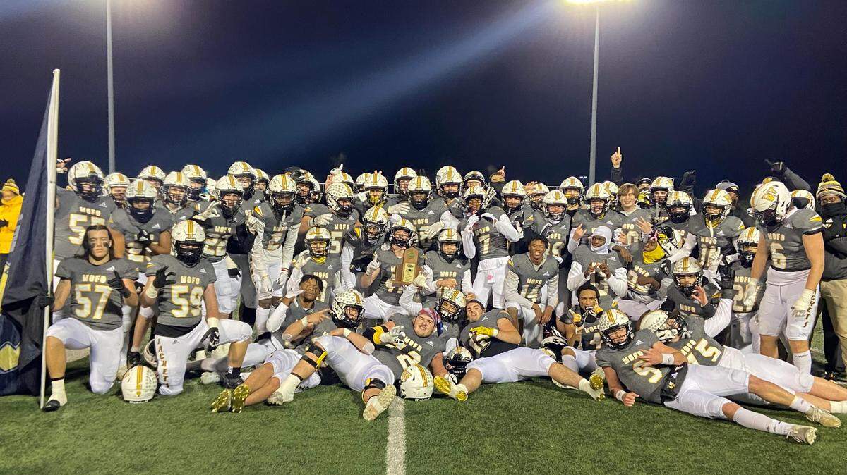 The Woodford County High School football team poses with its region championship trophy at Community Stadium in Versailles following a 28-14 victory over Covington Catholic in the third round of the KHSAA playoffs. Woodford County is now 13-0 this season, which is a school record for wins in one season.