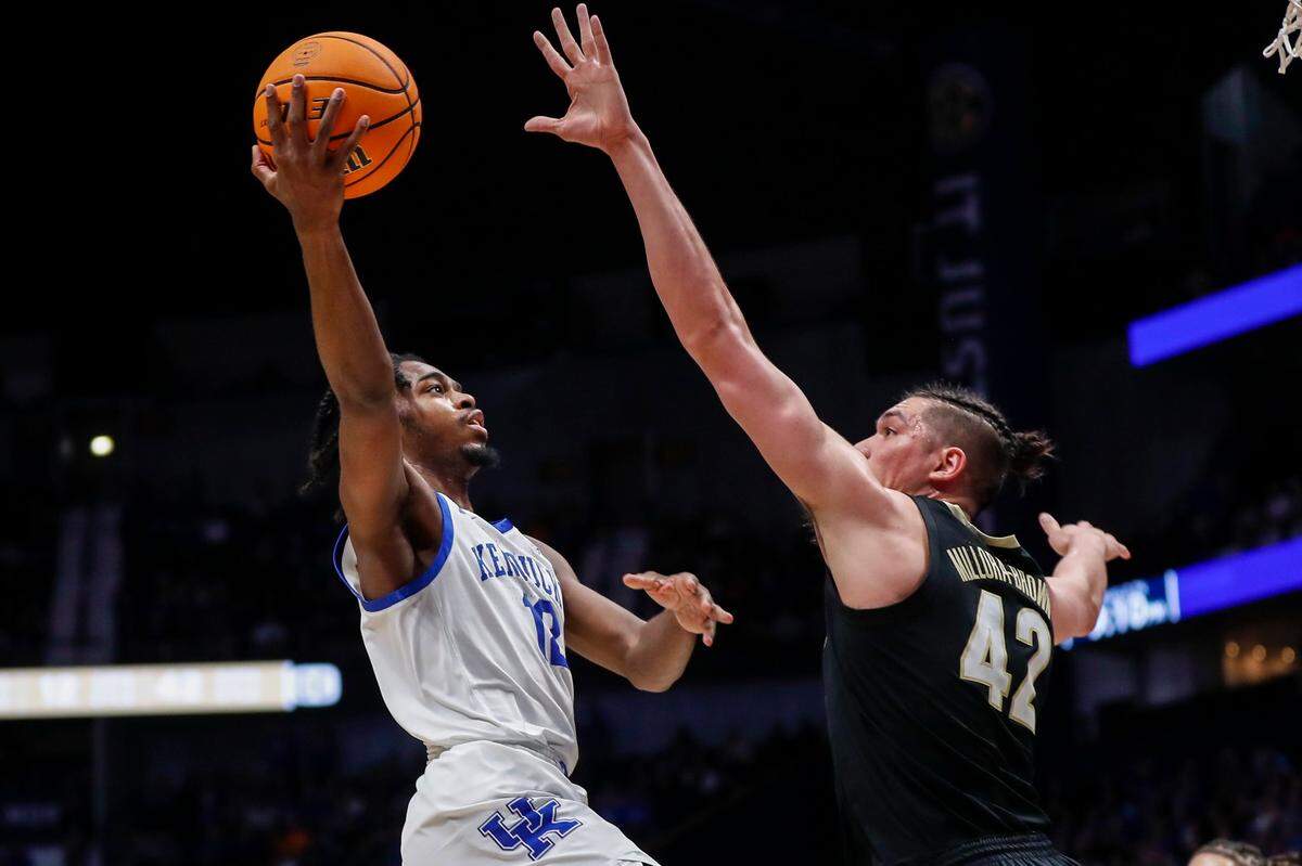 Kentucky’s Antonio Reeves (12) shoots over Vanderbilt’s Quentin Millora-Brown (42) during the SEC Tournament quarterfinals at Bridgestone Arena in Nashville on Friday. Reeves scored a team-high 22 points before fouling out.
