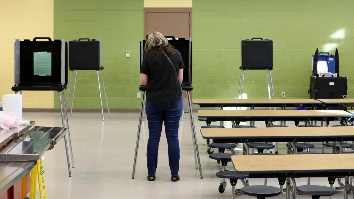 Voters cast their ballots during Kentucky’s Primary Election Day, Tuesday May 17, 2022 at the Fairway precinct in Lexington, Ky. Democrats and Republicans went to the polls to select candidates for the General Election in the fall. A new type of voting machine, first used in Kentucky’s 2022 Primary Election, is seen in the background at right. The machines, called the InterCivic are made by the Hart company. It uses a paper ballot, first filled out by the voter, and then scanned into the machine.