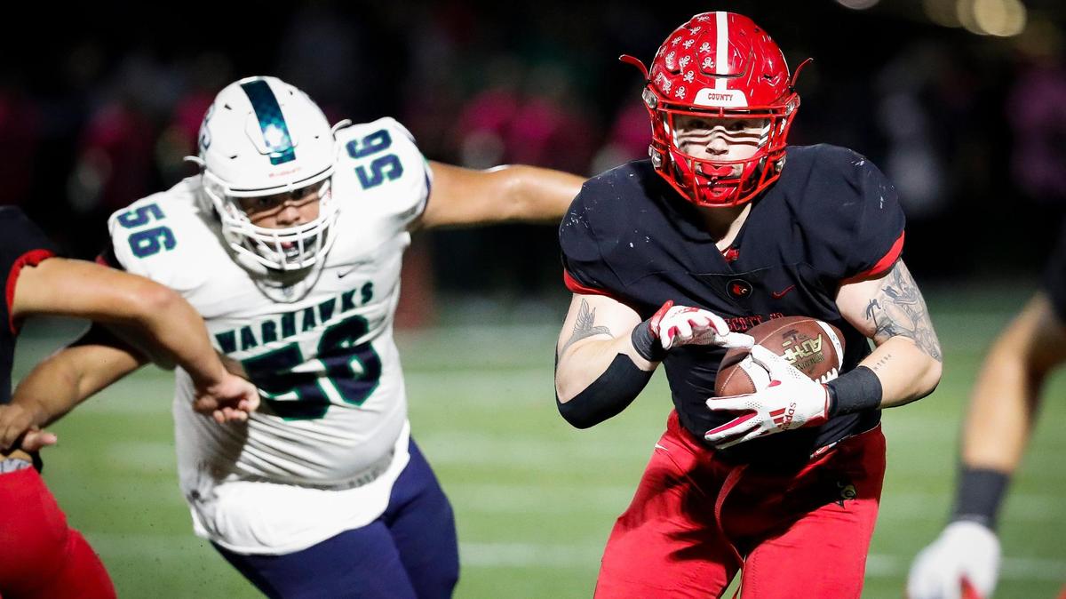 Scott County’s Campton Martin (5) runs the ball past Great Crossing’s Tre Combs (56) during a game at Great Crossing High School in Georgetown, Ky., Friday, Oct. 1, 2021. Scott County beat Great Crossing 14-6.