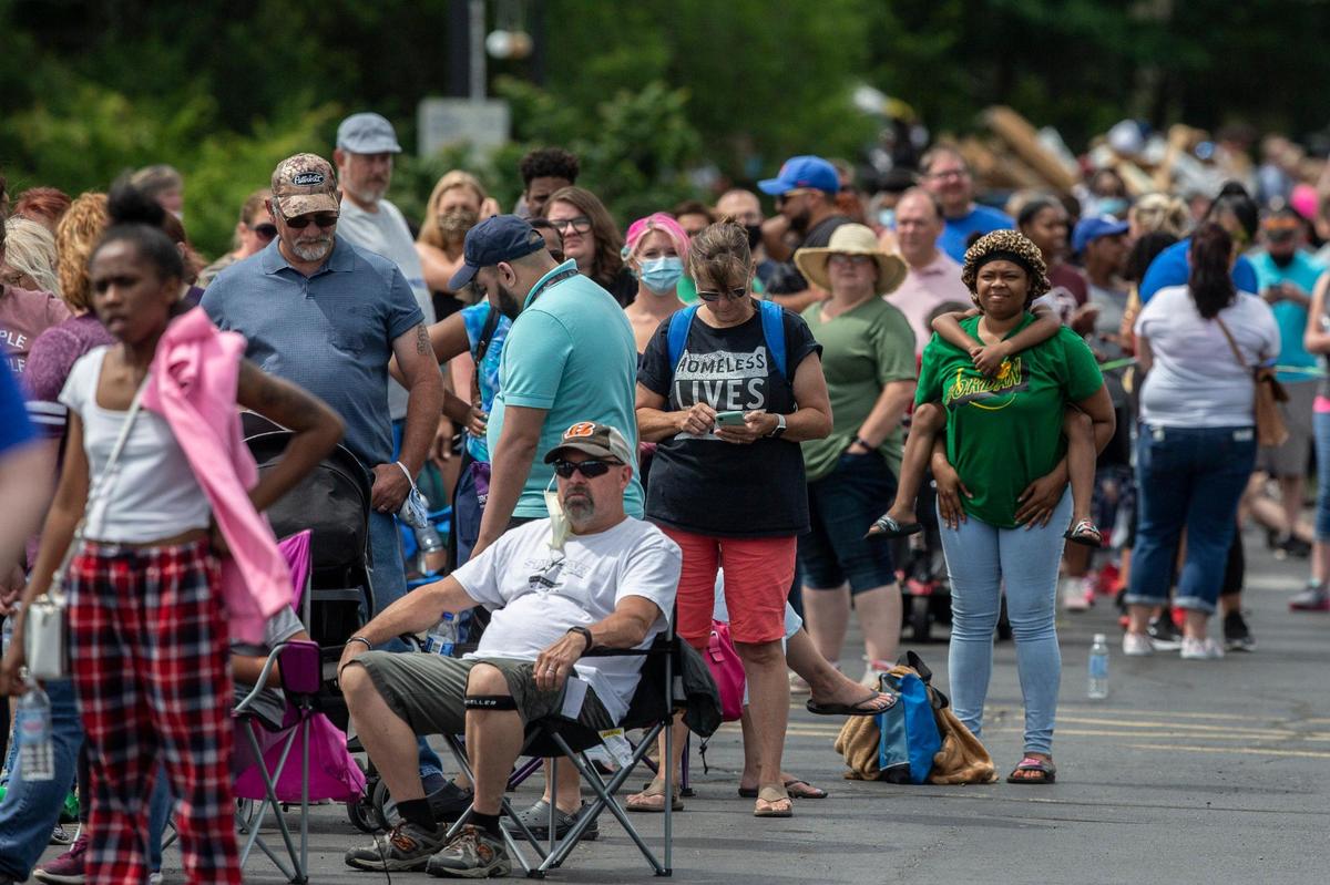 Hundreds of people wait in line for assistance with their unemployment benefits outside the Kentucky state Capitol in Frankfort, Ky., on Wednesday, June 17, 2020.