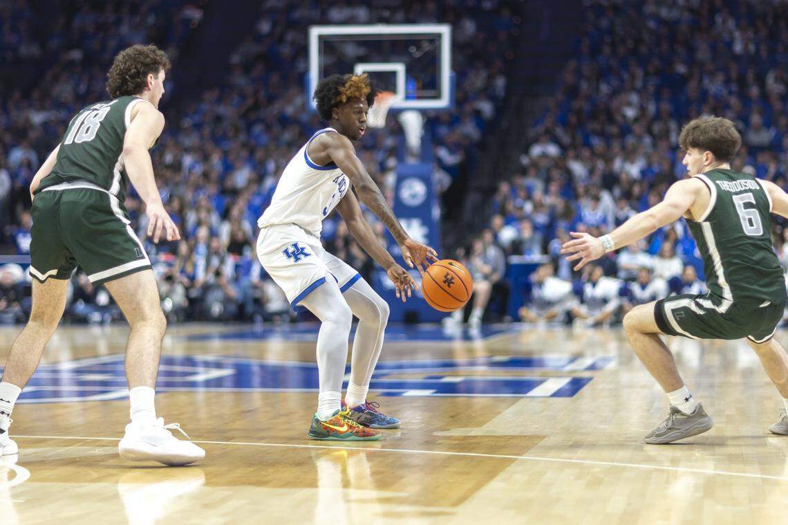 Kentucky guard Kam Williams, center, passes the ball around Loyola (Maryland) guard Jacob Theodosiou (6) during their game at Rupp Arena on Nov. 21.