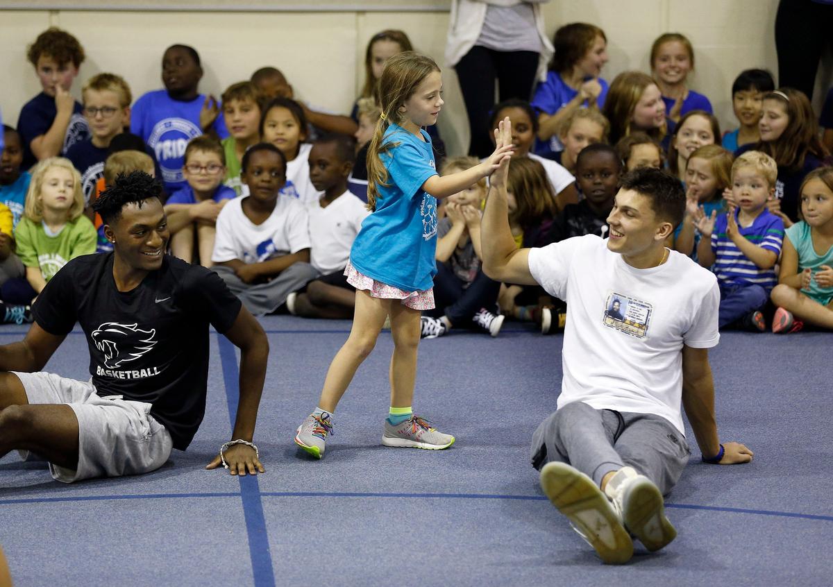 The Cats deliver for elementary studentsAddie Holcomb, a 6-year-old first-grader, high-fived player Tyler Herro after playing duck, duck, goose as nine members of the Kentucky men’s basketball team visited Picadome Elementary School Friday afternoon. The Wildcats delivered packed lunches to the school as a part of UK Athletics’ God’s Pantry program and then participated in physical education activities with the students. On the left is player Immanuel Quickley. Visit Kentucky.com to view additional photos and video.