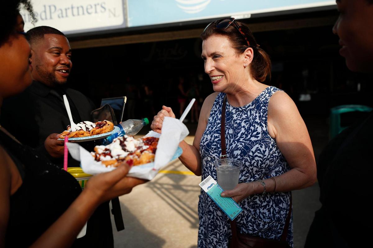 Artist Marjorie Guyon right, speaks with members of the Virtuosity group after their performance at Lexington Legends Ballpark June 26, 2021. Guyon created the “I Was Here” art project in Lexington.