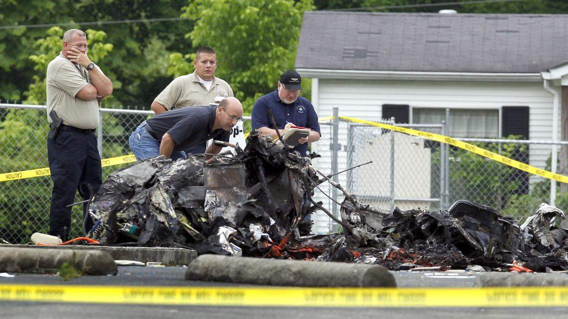 Officials looked over debris at the scene of a fatal helicopter crash on June 7, 2013, in Manchester. Location of parts indicated the aircraft was put under stress.