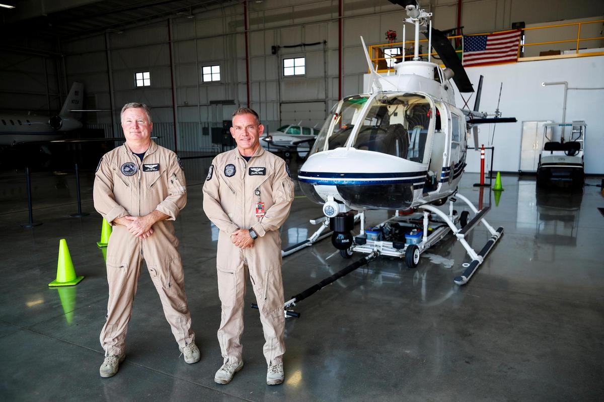 The Lexington Police’s Air Support Unit Coordinator Pat Murray and Tactical Flight Officer Bige Towery in front of one of the two Bell OH-58C helicopters used by the unit at the Bluegrass Airport in Lexington, Ky., Tuesday, July 15, 2022.