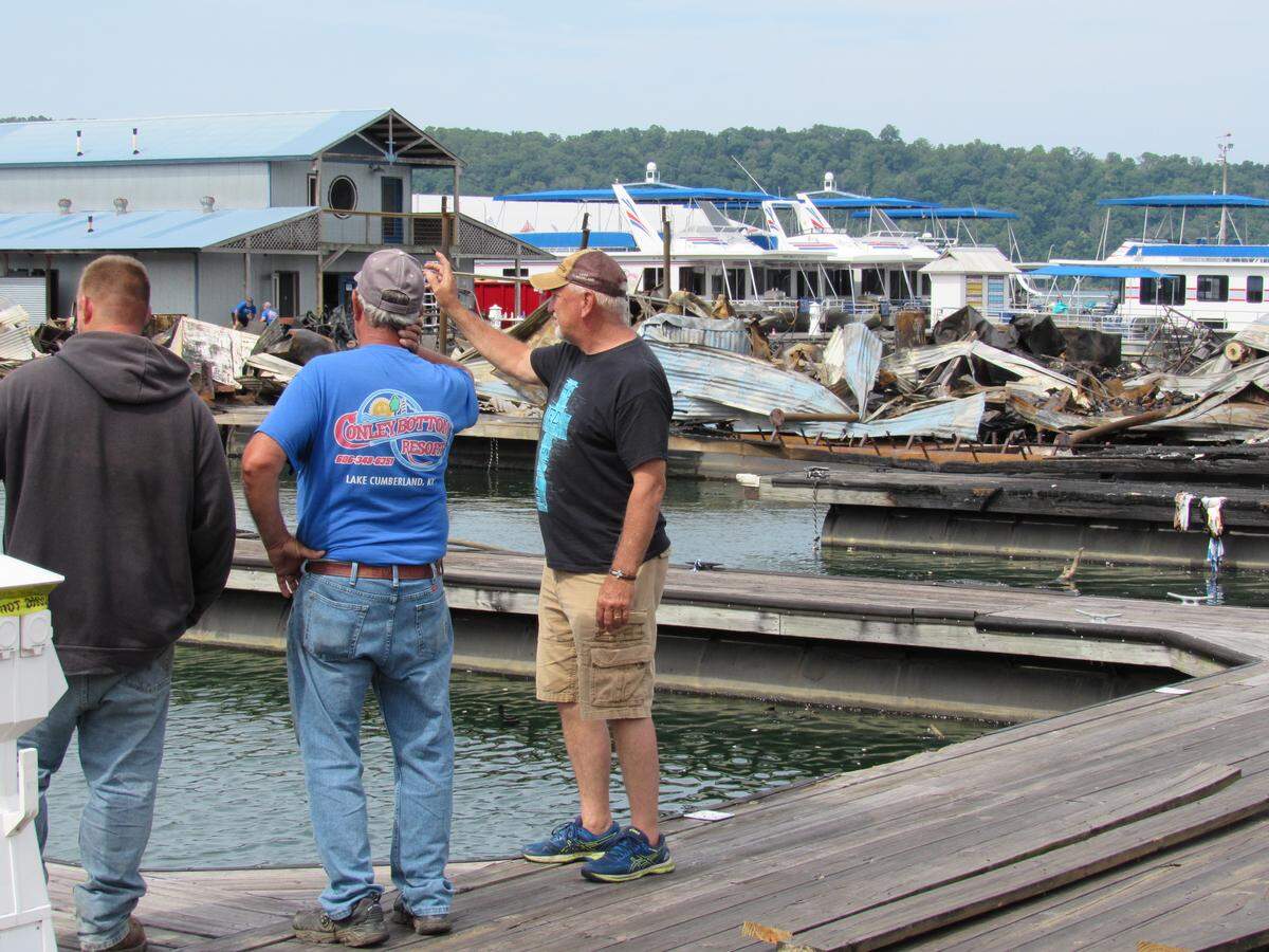Fred Piercy, right, the owner of Conley Bottom Resort on Lake Cumberland, talks with employees on May 23, 2019 as they work to make repairs after a fire at the marina.