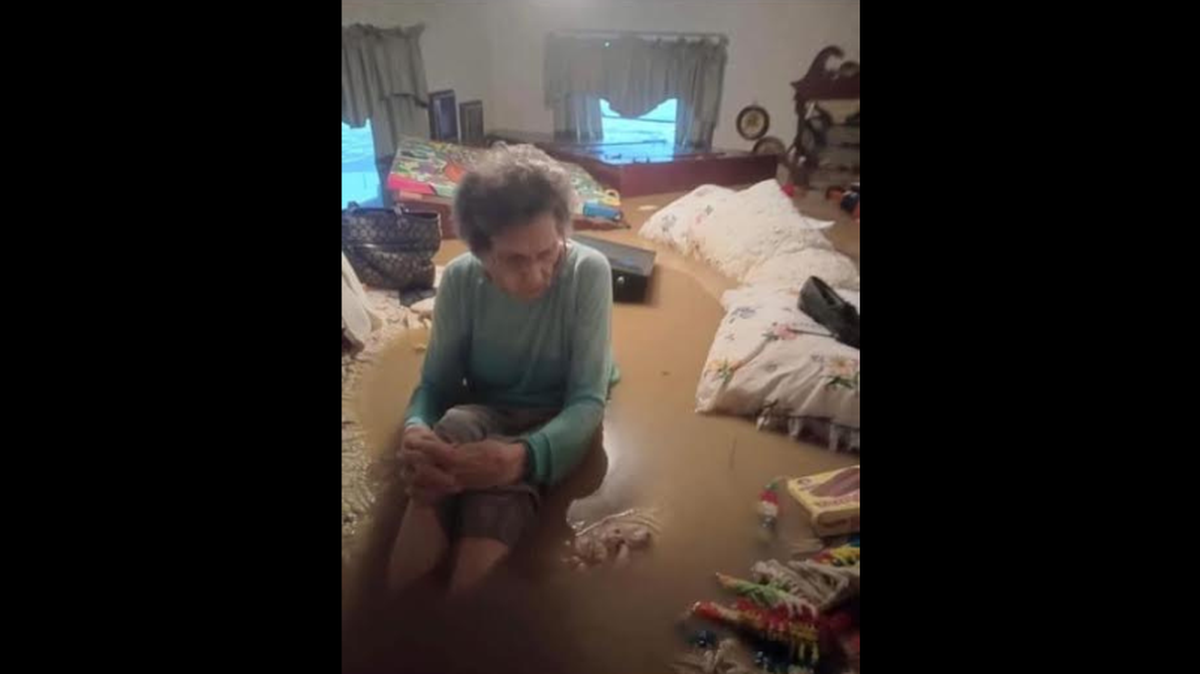 Mae Amburgey, 97, sits in her home in Letcher County on July 28, 2022 surrounded by water after catastrophic flooding in Kentucky. She died Oct. 8.