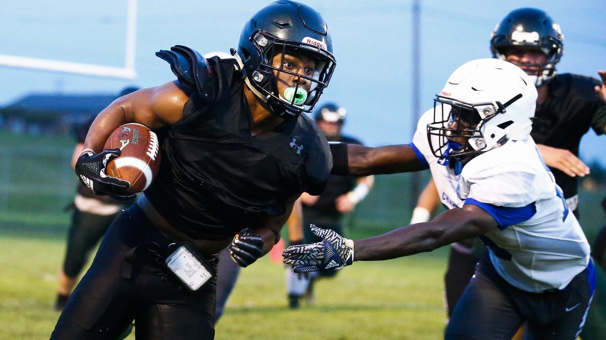 Western Hills’ Wandale Robinson (1) carried the ball past Lexington Christian’s Xavier Brown (20) to score a touchdown during their scrimmage in Frankfort last weekend. Robinson started playing football in Louisville when he was 5 years old.