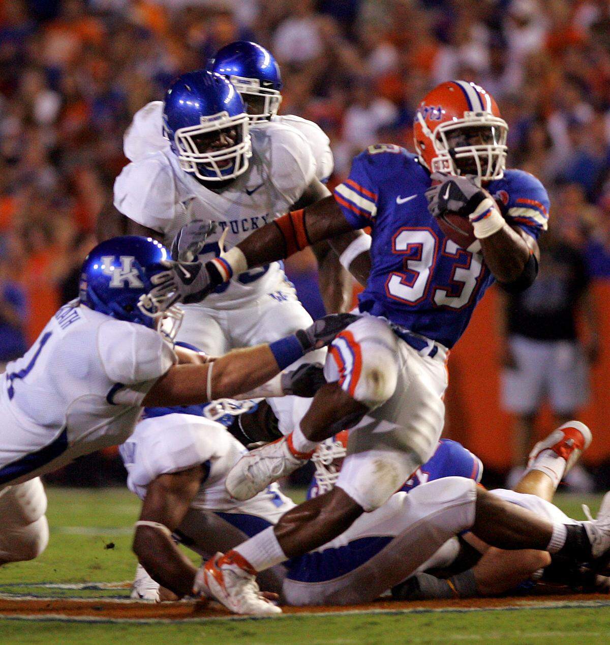 Kentucky’s Austin Moss, center, tried to track down Florida’s Kestahn Moore during a game in Gainesville in 2006.