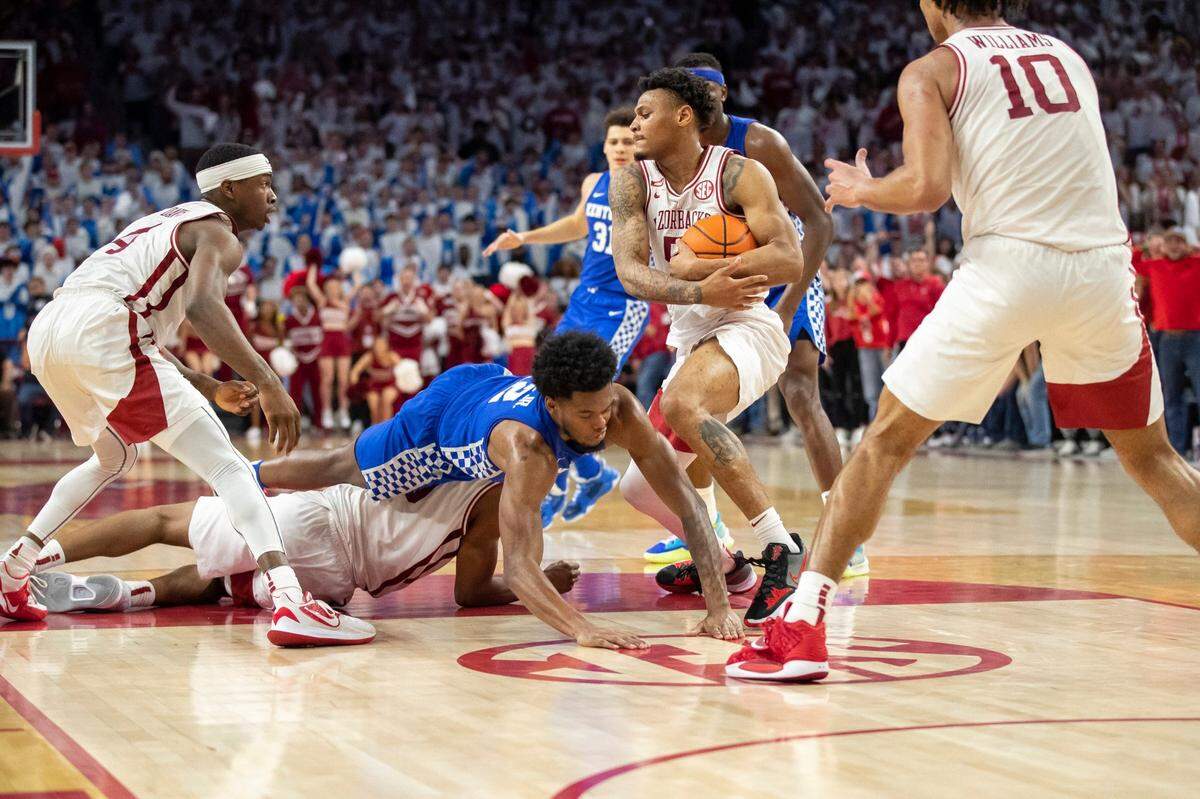 Arkansas Razorbacks forward Kamani Johnson (20) recovers a loose ball in the final seconds of a game against the Kentucky Wildcats at Bud Walton Arena in Fayetteville, Ark., on Saturday, Feb. 26, 2022.