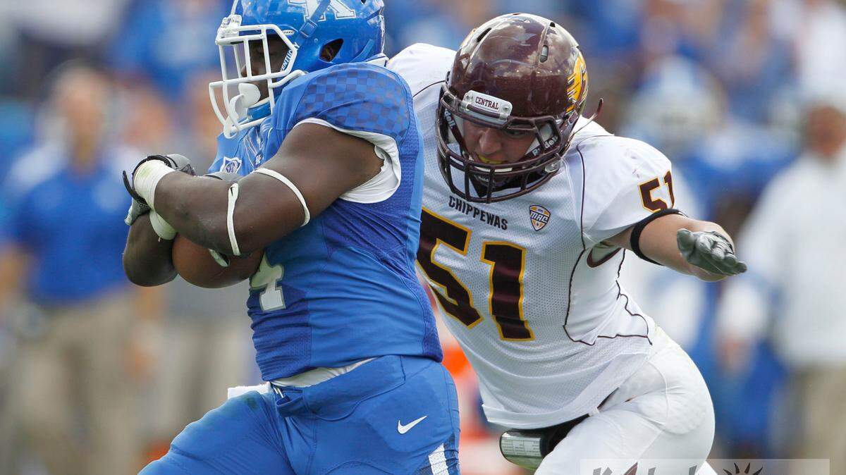 UK's Raymond Sanders, left, protected the ball as CMU's Cody Lopez closed in for the tackle in the second half of the University of Kentucky vs. Central Michigan University football game on Saturday, Sept. 10, 2011 at Commonwealth Stadium in Lexington, Ky.   Kentucky won 27-13. Photo by David Perry  |  Staff