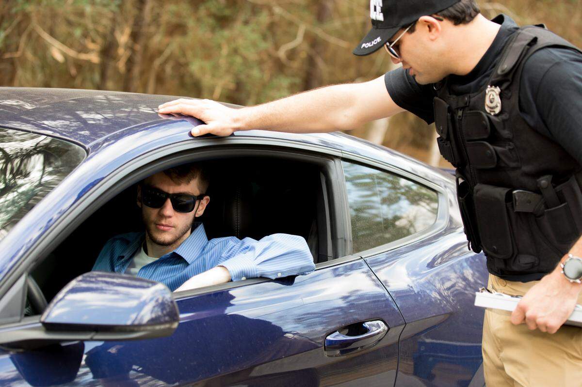 A police officer speaks to a driver during a traffic stop.