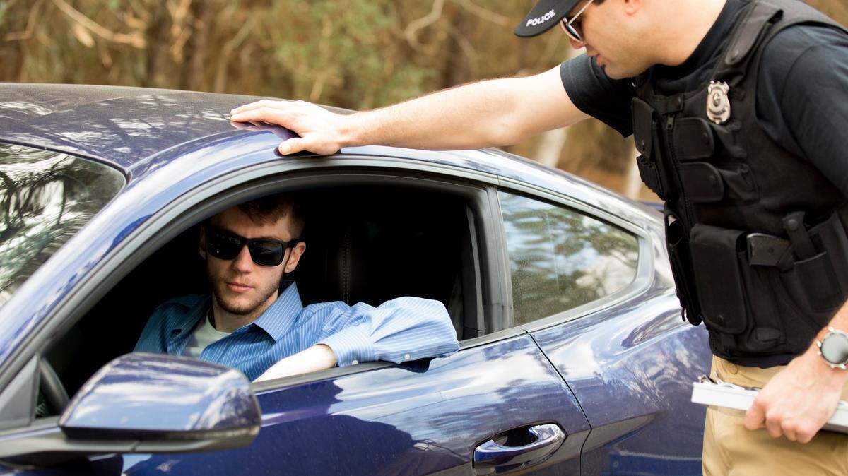 A police officer speaks to a driver during a traffic stop.