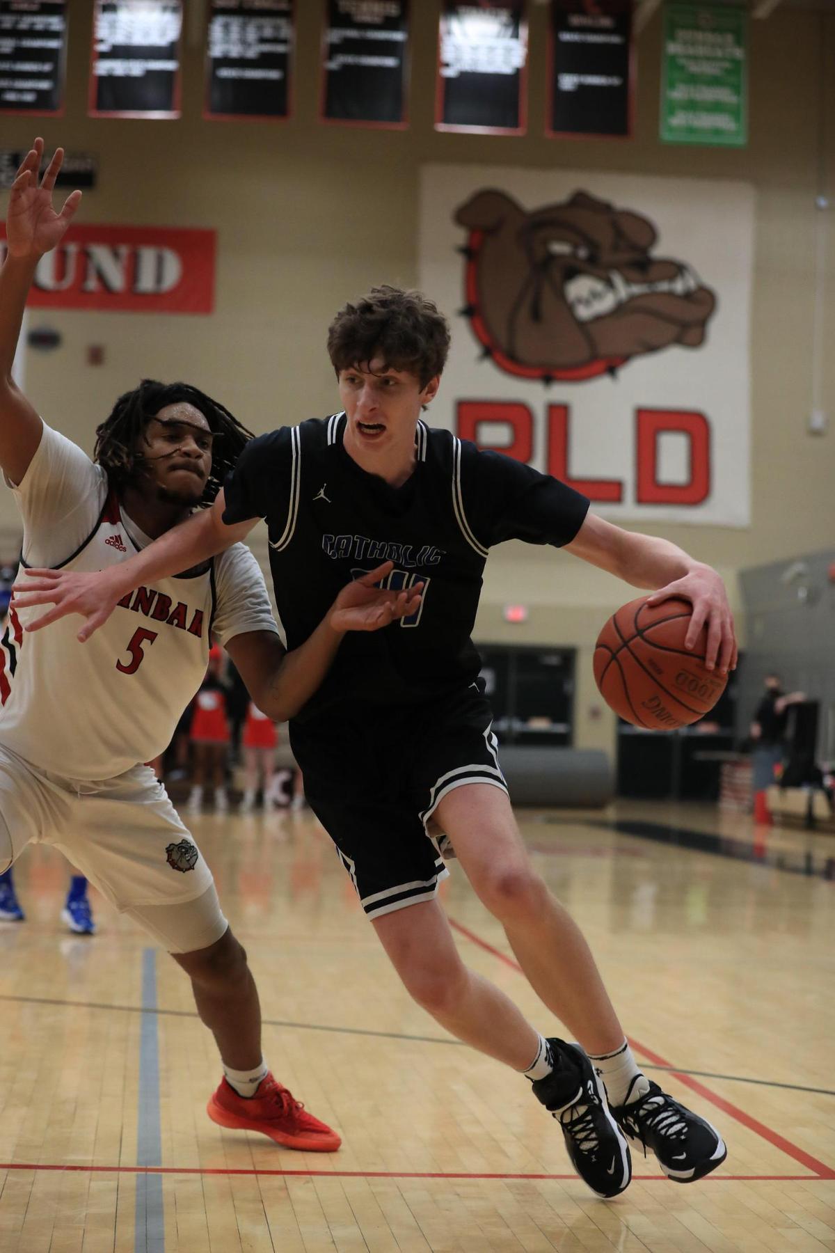 Lexington Catholic’s Reece Potter (34) drove around the defense of Paul Laurence Dunbar’s Shyheim Drew (5) during the Knights’ 61-56 win over the Bulldogs.