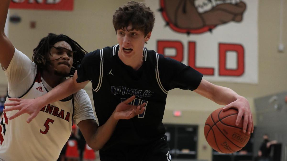 Lexington Catholic’s Reece Potter (34) drove around the defense of Paul Laurence Dunbar’s Shyheim Drew (5) during the Knights’ 61-56 win over the Bulldogs.