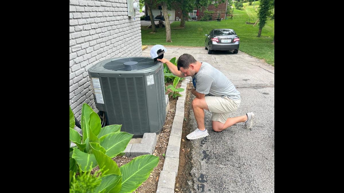Frankfort, Ky., native Ryan Sturm kneels beside his air conditioning unit for a Facebook post.