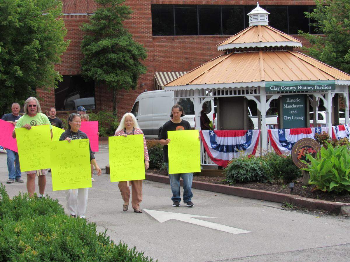 Opponents of a plan by the County Board of Education to move graves in a cemetery on a hill overlooking an elementary school protested in downtown Manchester on July 8, 2021.