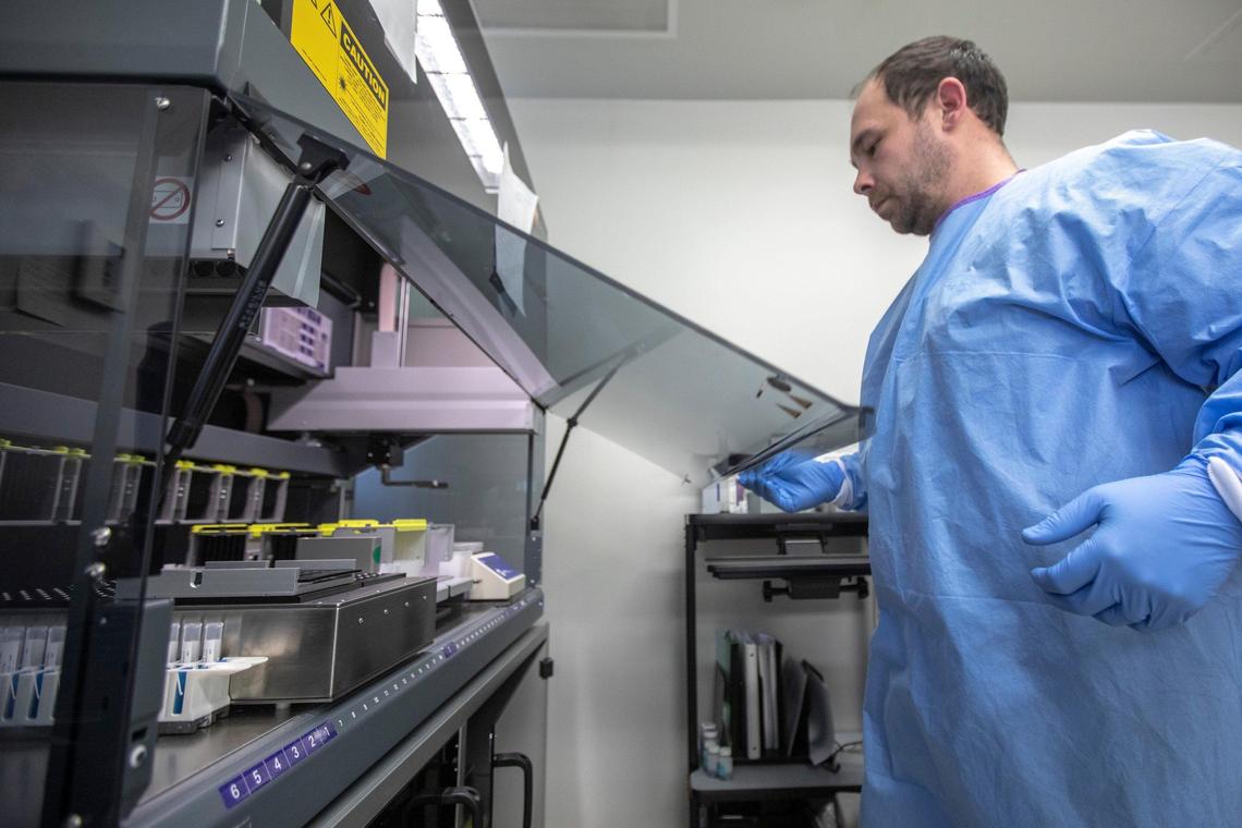 Ben Cobb, lead molecular microbiologist, prepares an instrument to test specimen for Covid-19 at the University of Kentucky Medical Center Clinical Microbiology Lab in Lexington, Ky., on Tuesday, March 25, 2020.
