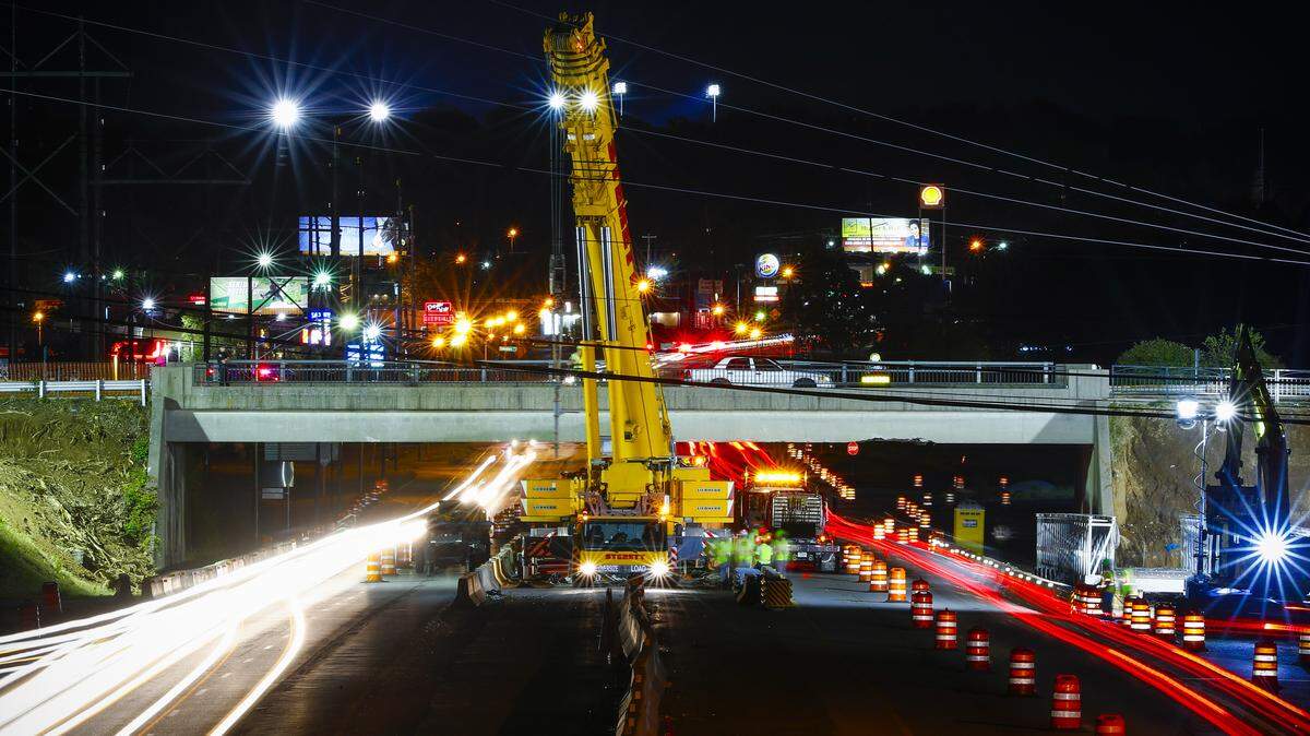 Motorists drive along New Circle Road as crews work to set a temporary pedestrian bridge along the Legacy Trail at the Lexmark Bridge in Lexington, Ky., Thursday, Sept. 10, 2019.