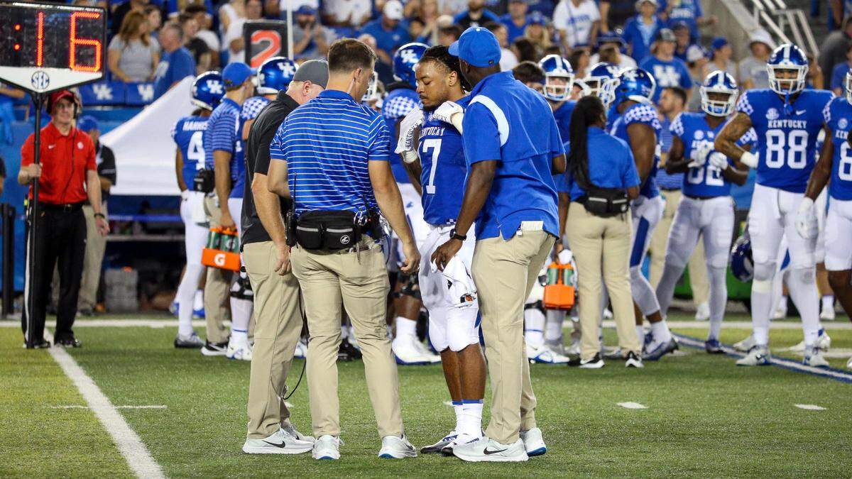 Kentucky head coach Mark Stoops, left, and team trainers check on running back JuTahn McClain (17) after his injury during the second half against Miami (Ohio) on Saturday night.