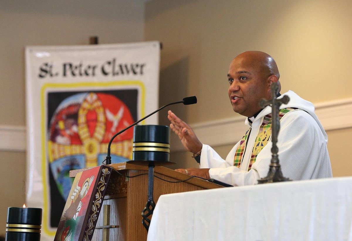 Father Norman Fischer led the congregation in prayer Sunday at St. Peter Claver during a healing prayer service for racial reconciliation to mark the 400th anniversary of slavery in the United States. Photo by Matt Goins