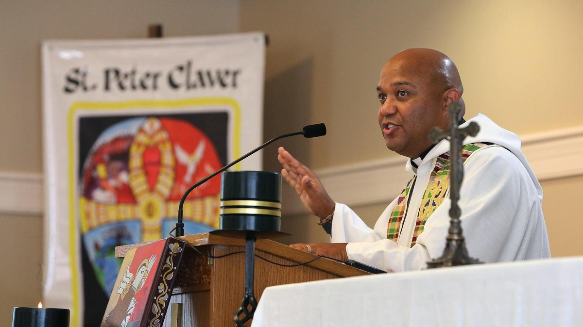 Father Norman Fischer led the congregation in prayer Sunday at St. Peter Claver during a healing prayer service for racial reconciliation to mark the 400th anniversary of slavery in the United States. Photo by Matt Goins