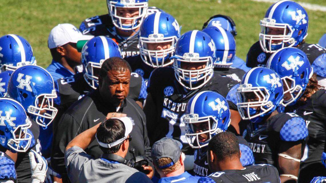 UK recruiting coordinator Vince Marrow (center, facing camera) huddled with then-offensive coordinator Neal Brown, Coach Mark Stoops and the UK offense during a 2013 game against Louisville.