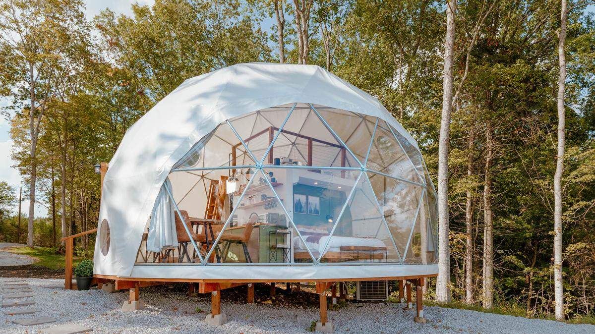 A gorgeous geodesic dome with panoramic views of Kentucky’s countryside is the state’s most wish-listed Airbnb stay in 2025. Here we see it pictured. The dome is made of glass and is perched on stilts.