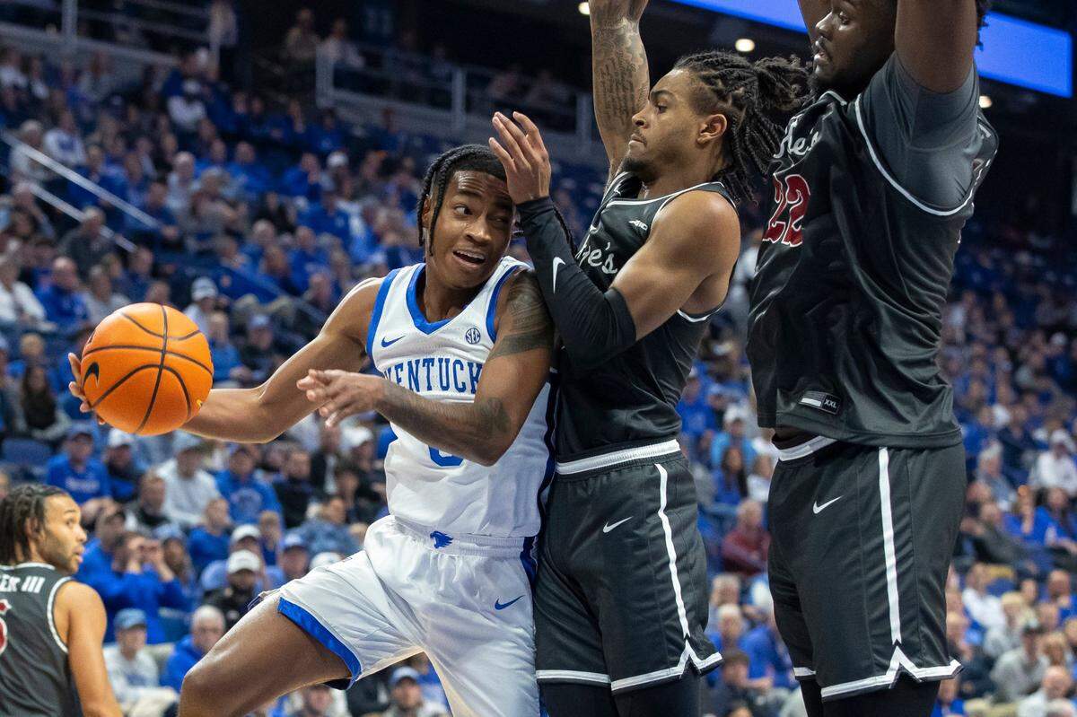Kentucky guard Rob Dillingham (0) looks to make a play as Saint Joseph’s guard Erik Reynolds II (2) and Saint Joseph’s center Christ Essandoko (22) defend.
