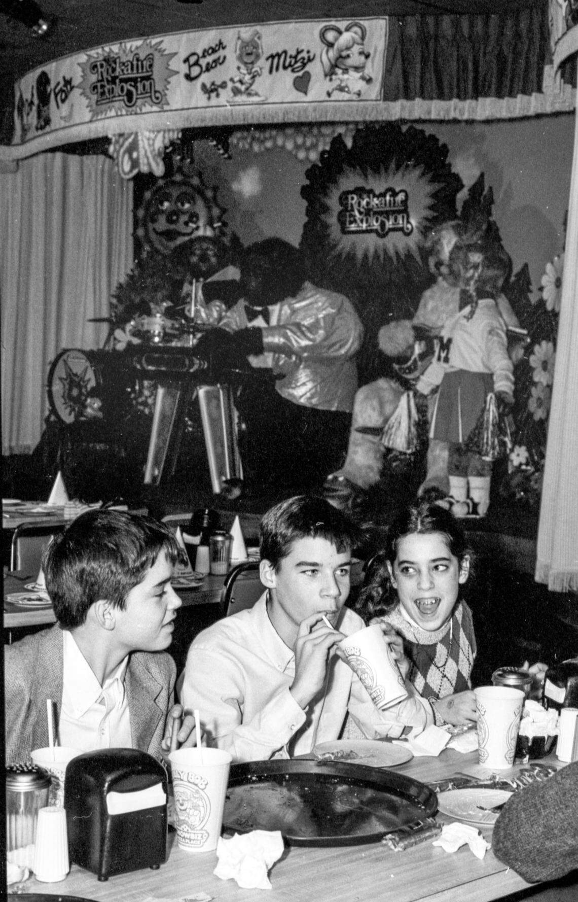 Kids eat pizza and drink soda as the Rock-afire Explosion animatronic band plays in the background at ShowBiz Pizza Place, Wednesday, Jan. 4, 1984 at Woodhill Circle Plaza in Lexington, Ky. The mechanical figure band was one of the main attractions of the family pizza and entertainment restaurant, their life like appearances attracting big crowds. Onstage, the furry robots entertained by singing favorite pop tunes with shows every three minutes, nine different shows in all. In 1991 the restaurant was rebranded Chuck E. Cheese and in 2025 it closed. Photo by Christy Porter, Herald-Leader file photo